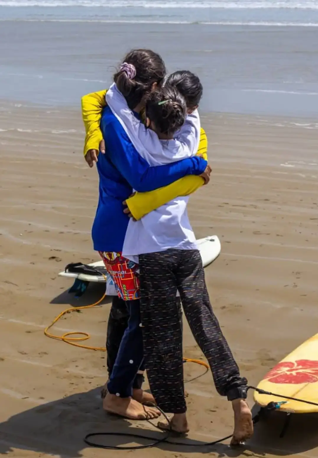 سه دختر موج‌سوار باشگاه رمین پس از تمرین در ساحل